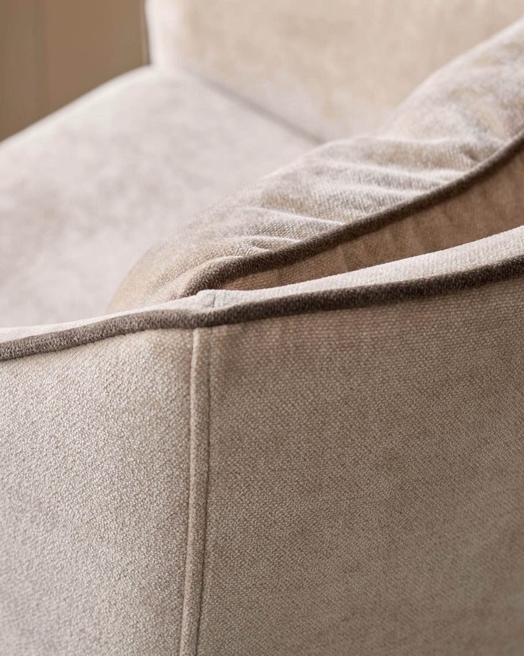 Champagne fabric bar stool detail showing plush upholstery texture and curved armrest seam.