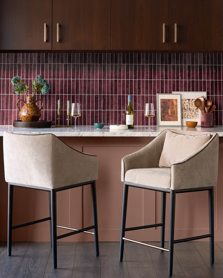 Champagne fabric bar stool with black metal frame and footrest, shown in kitchen setting at counter.