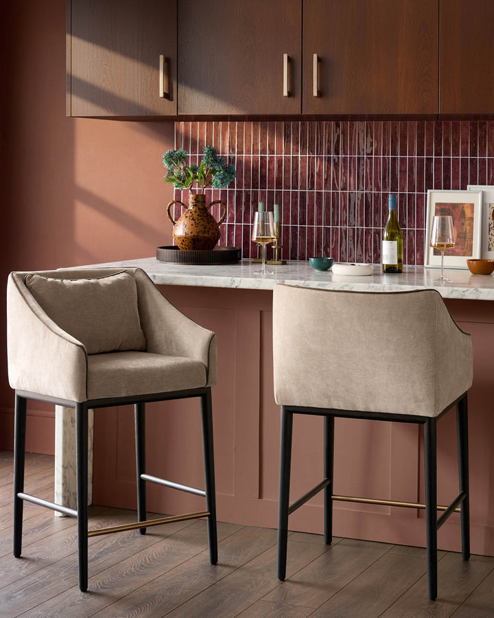 Champagne fabric bar stool with black metal frame and footrest, shown in kitchen setting.