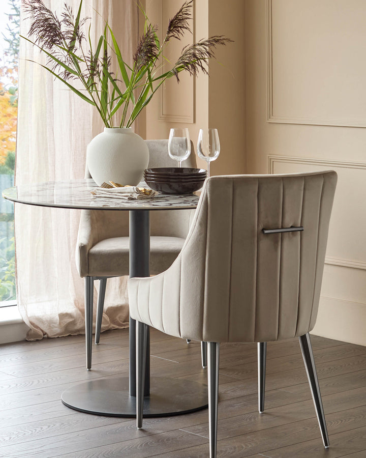 Champagne velvet dining chair with vertical channel quilting, stainless steel legs, shown at round marble table.