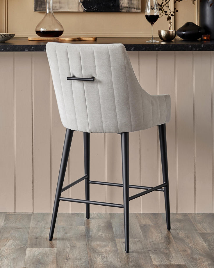 Upholstered bar stool with black legs. The stool back has a modern, straight-line design.