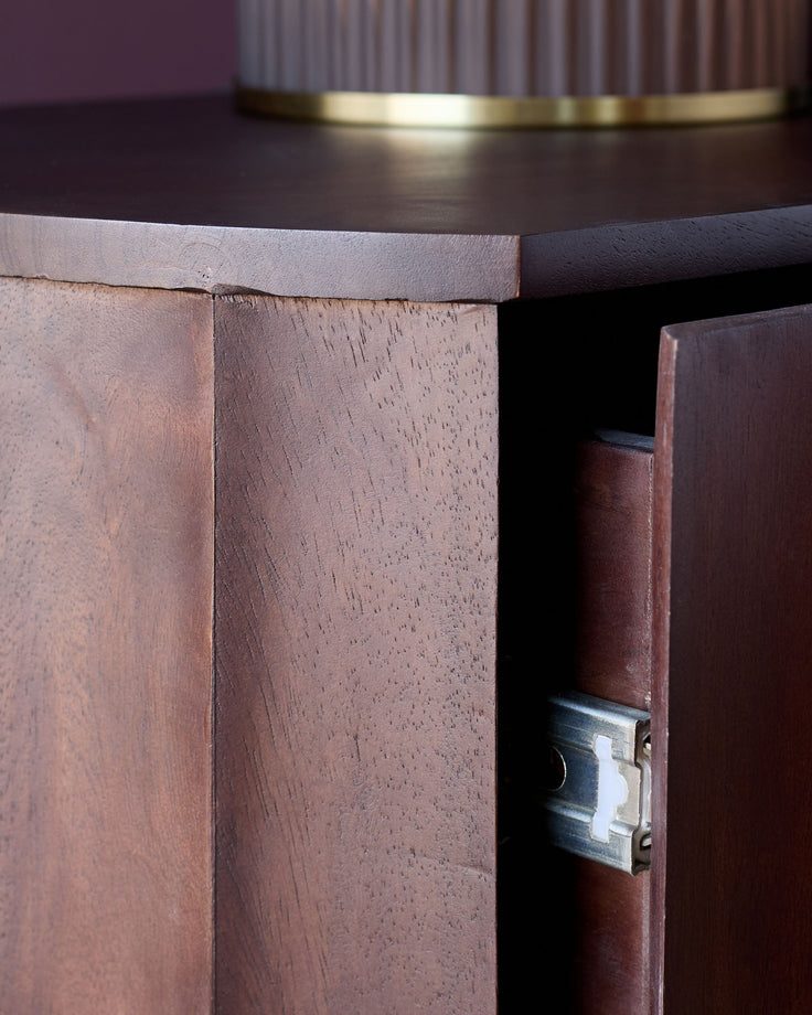 Dark mango wood bedside table with metal handle detail and open drawer revealing interior storage.