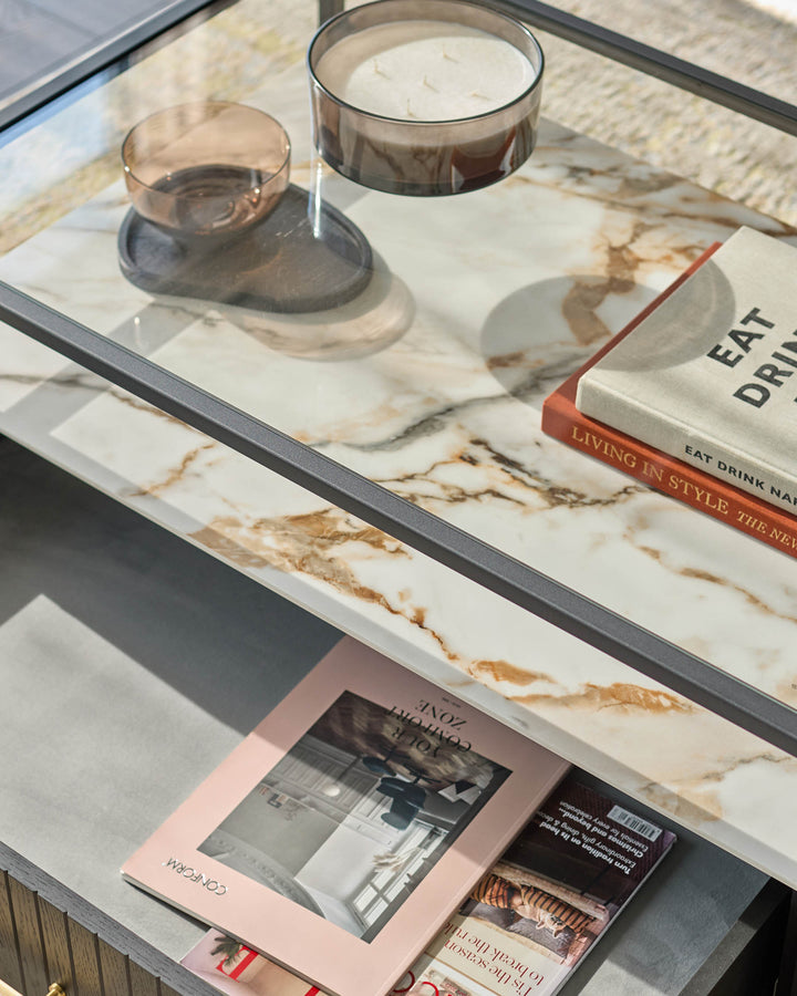 A stylish coffee table with marble top, featuring elegant candles, books, and magazines. A modern touch for any living space.