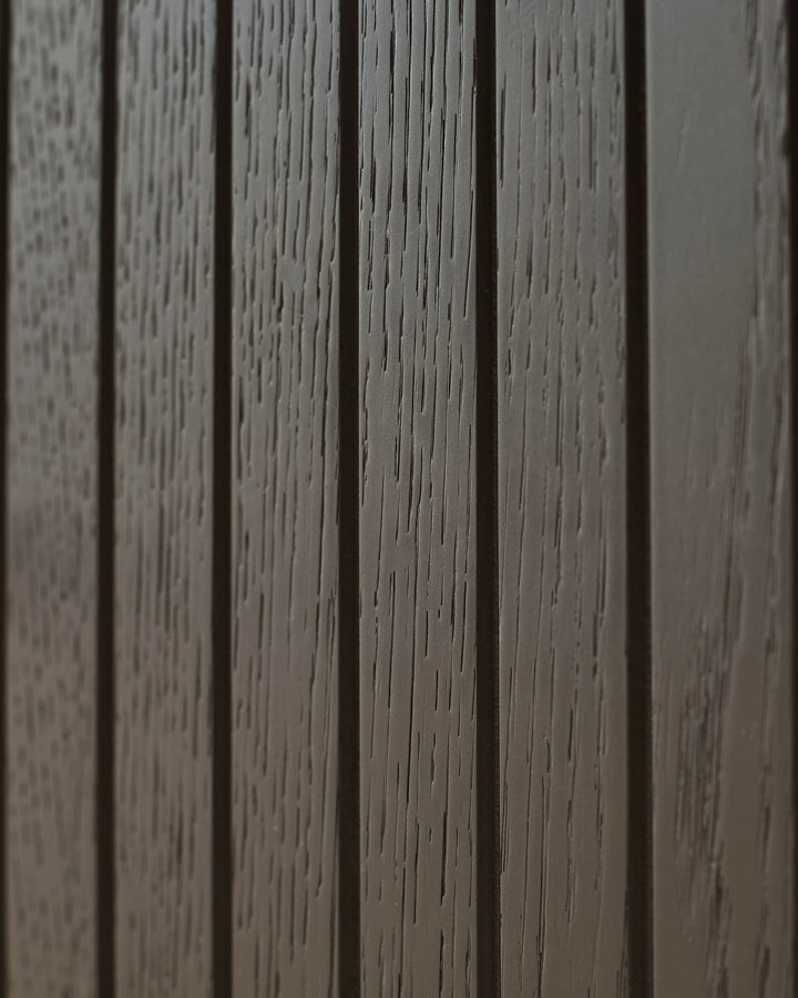Close-up of a wooden panelled wall, showcasing the textured surface and depth of colour of the furniture.
