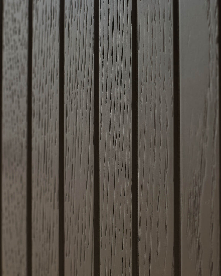 Close-up of a wooden panelled wall, showcasing the textured surface and depth of colour of the furniture.