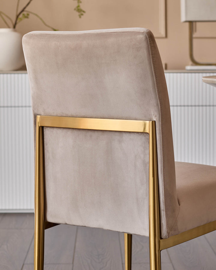 Keira velvet dining chair in champagne with gold metal frame, shown from back angle in neutral interior setting.