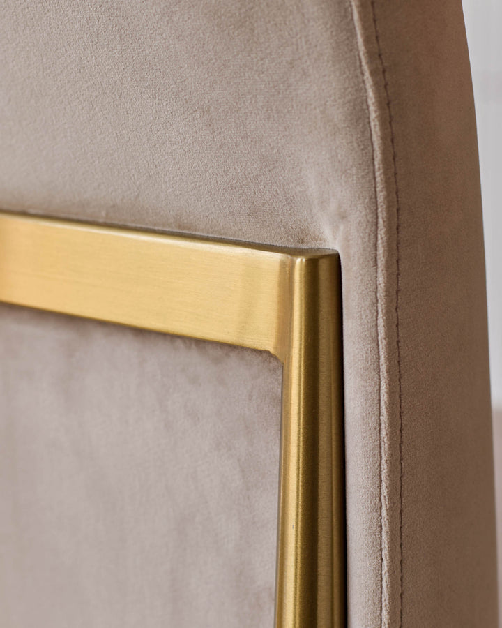 Keira velvet dining chair in champagne with brushed gold metal frame detail, close-up of corner joint.