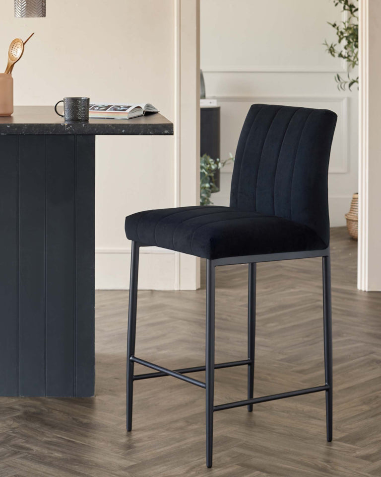 Elegant modern bar stool with plush, vertical channel tufting on the backrest, upholstered in a deep navy blue velvet fabric, featuring a comfortable padded seat and a sturdy metal frame with sleek black finish and footrest bar.