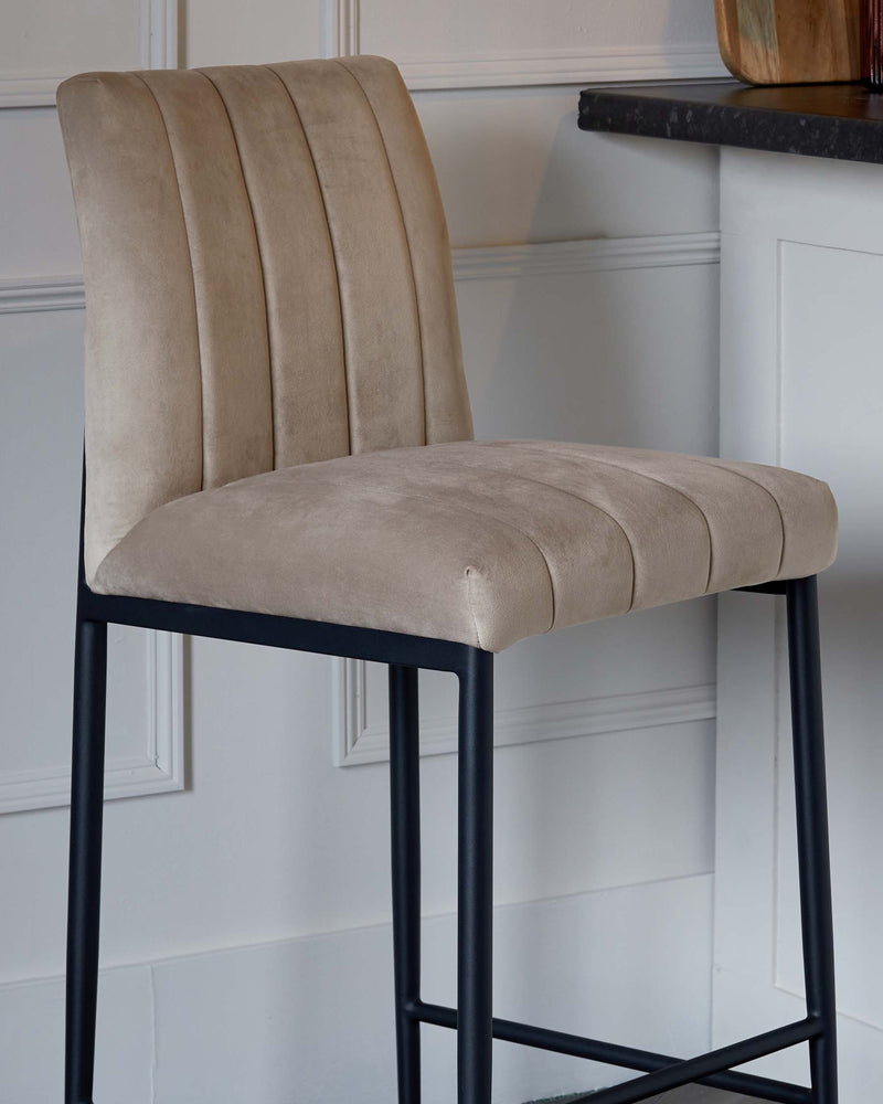 Elegant contemporary bar stool with a high-back design, upholstered in a soft taupe fabric featuring vertical stitching. It stands on a slender, matte black metal frame with four legs and footrests.