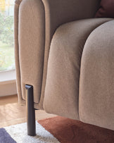 Close-up of a beige, textured sofa with dark legs, showcasing its plush design and sturdy build.