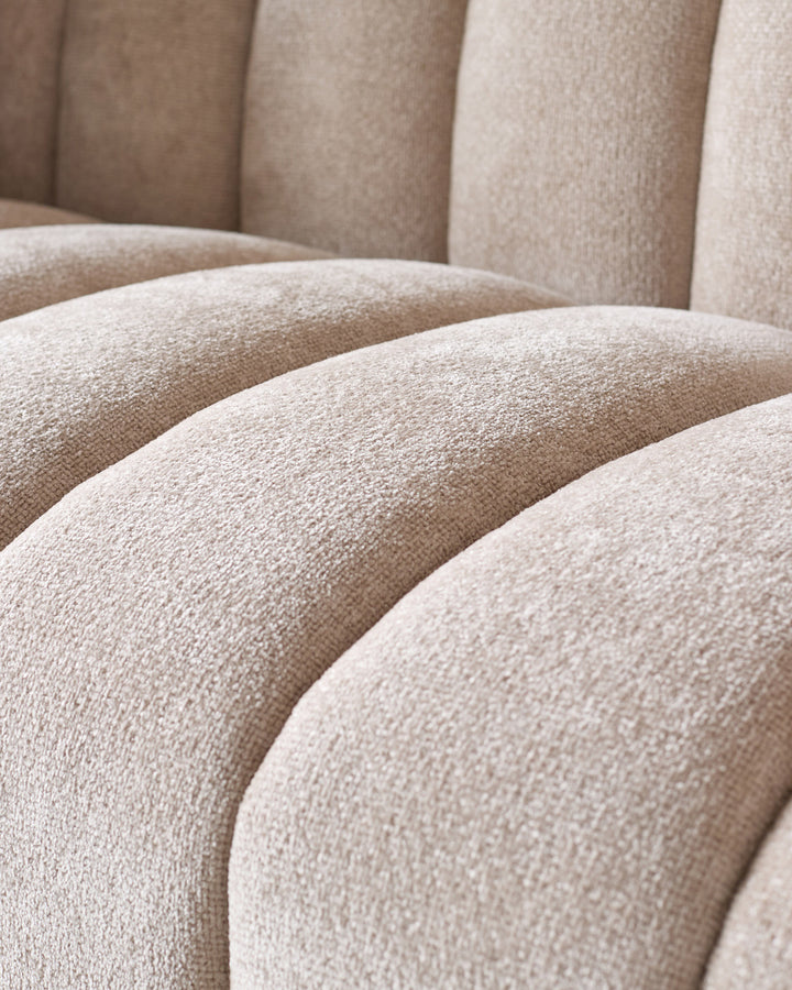 Kendra 3-seater sofa in natural fabric, close-up detail showing curved seating with textured weave finish.
