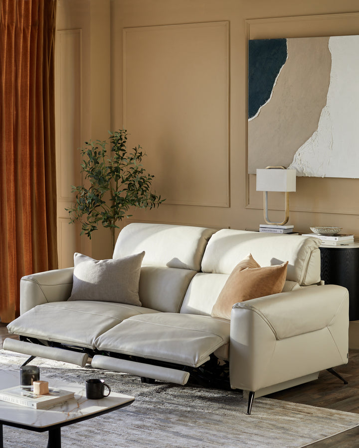 A stylish, modern cream leather sofa with extended leg rests, situated in a neutral-toned living room setting.
