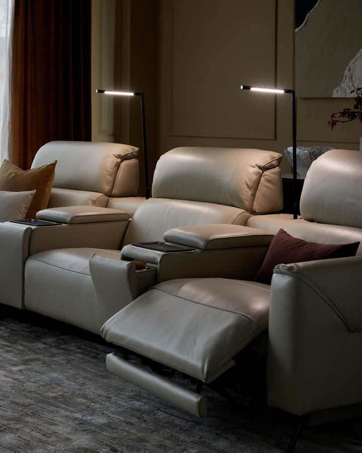 A cream leather reclining sofa with adjustable headrests and lights, providing ultimate comfort and style.