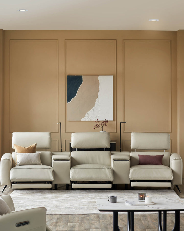 Cream-coloured reclining theatre seating with a central console and marble table. Modern, stylish and comfy.