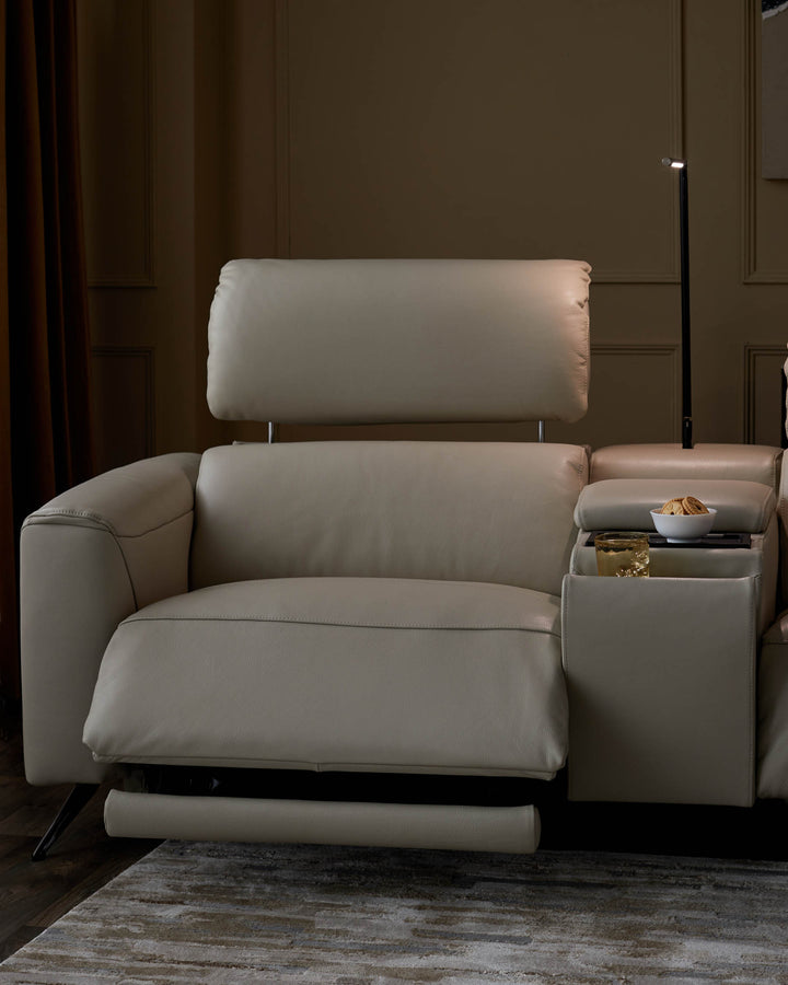 Close-up of a beige leather recliner sofa with a tray table holding a bowl of biscuits and a glass of liquid.