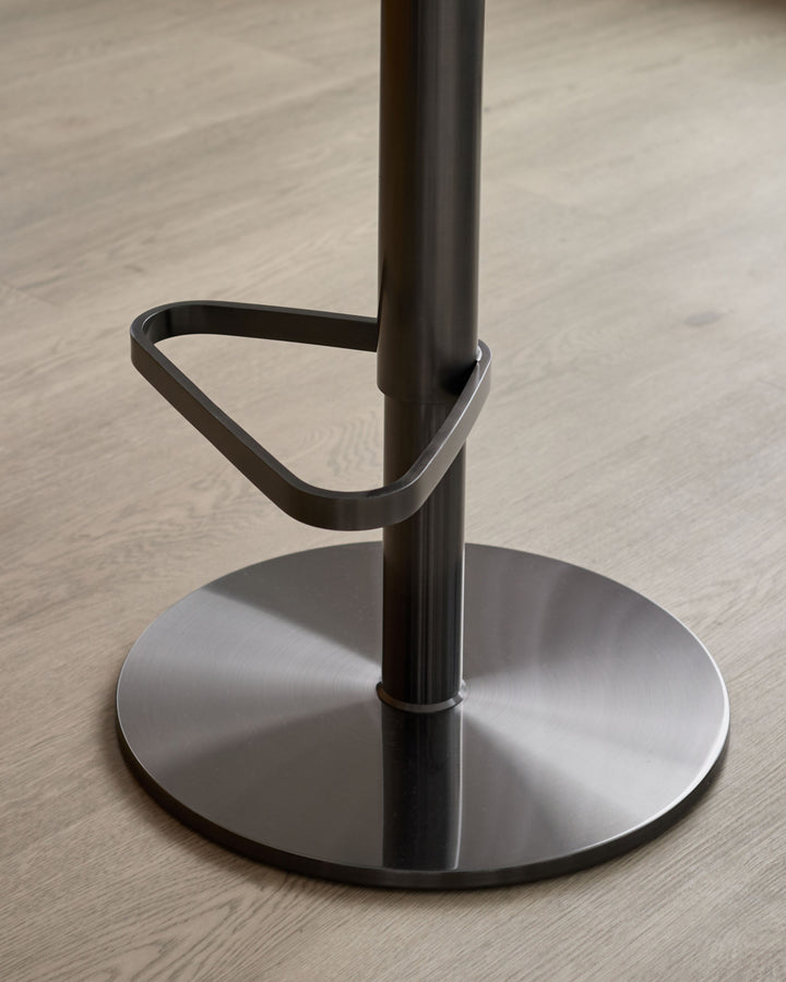 Kian gas lift bar stool base detail showing brushed metal circular footrest, black metal pole, and triangular handle grip.
