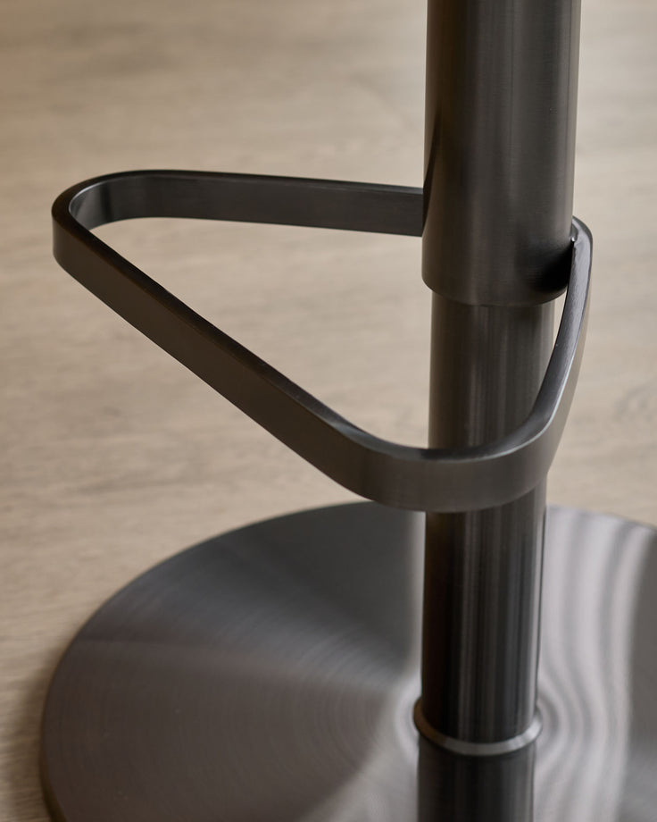 Black gas lift bar stool with grey fabric seat, showing curved backrest and cylindrical metal base detail.