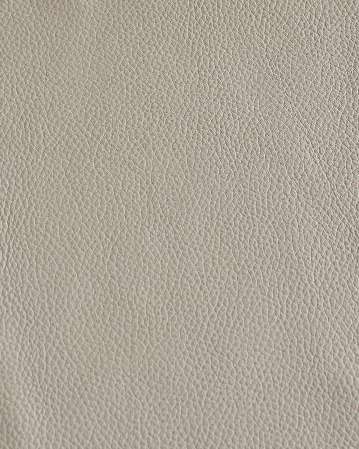 Close-up of light grey leather. Neutral tone, fine grain, classic texture, ideal for high-end upholstery, furniture and design.
