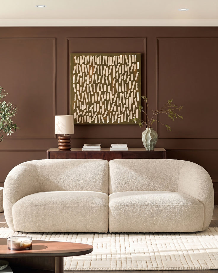Kimberley 3-seater sofa in natural fabric with rounded, curved silhouette, displayed in a styled living room setting.