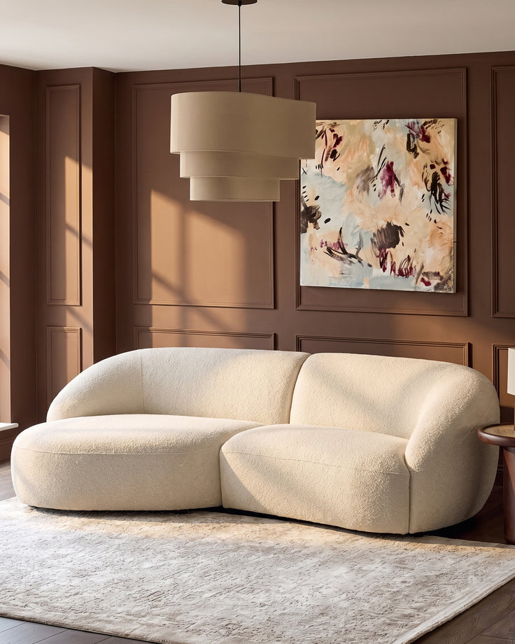 Kimberley left-hand chaise 3-seater sofa in natural fabric with curved, rounded design in warm cream living room setting.