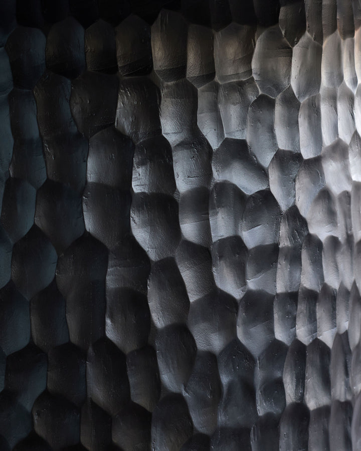 Close-up of black wood texture showing scaled surface detail on Knox dining table