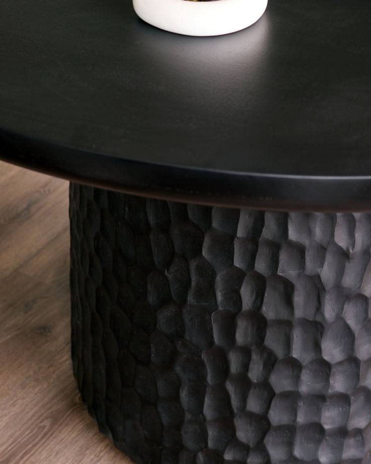 Close-up of Knox dining table base showing textured black wood pedestal with honeycomb pattern detail.