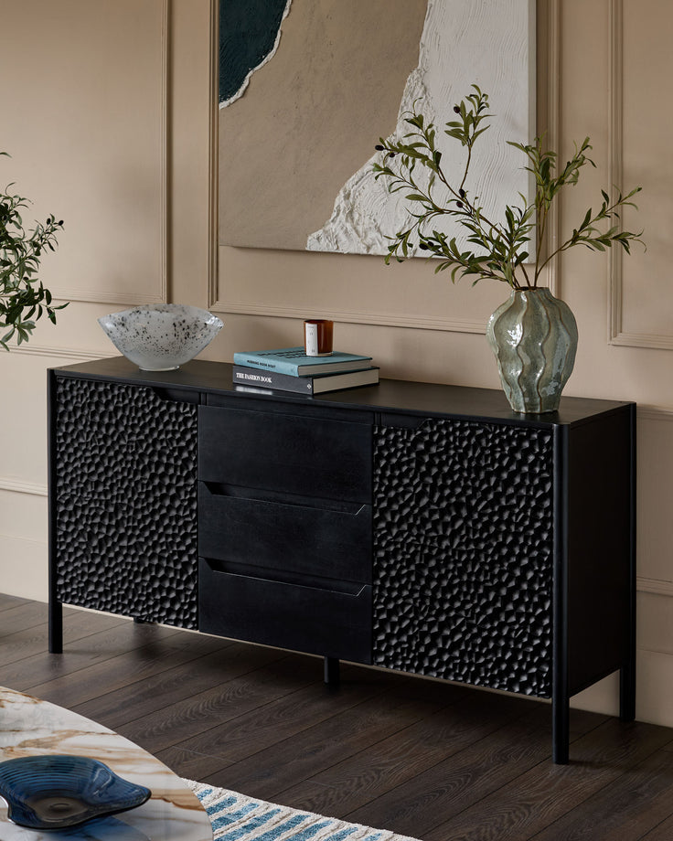 Knox large sideboard in black wood with textured cabinet doors, displayed in a modern living room setting.