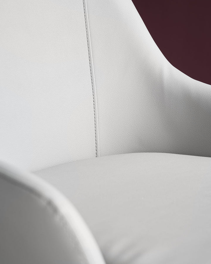 Close-up detail of Kyro faux leather dining chair in light grey, showing textured seat surface and stitched seam.