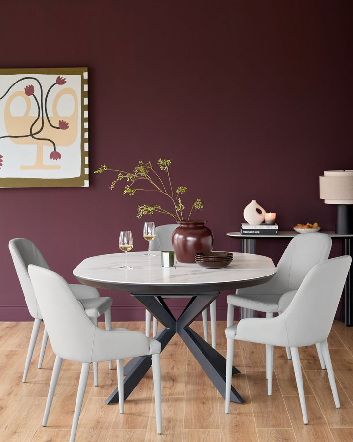 Light grey faux leather dining chair with curved backrest and white legs, shown in a modern dining room setting.