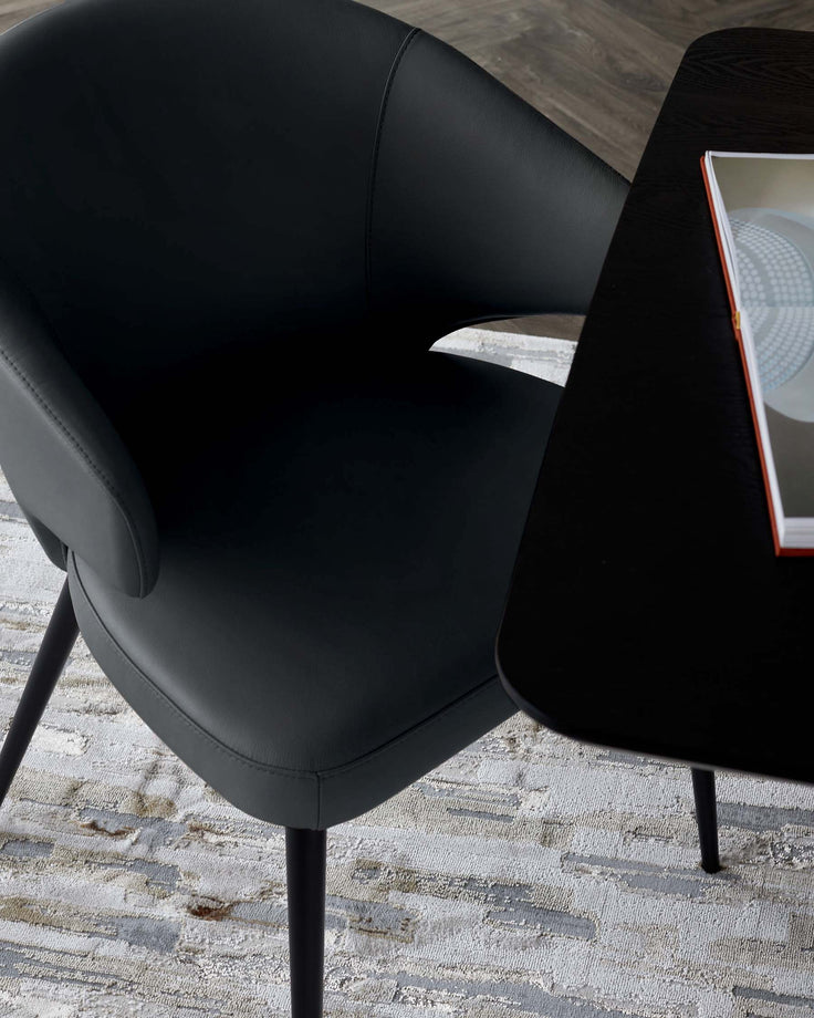 Black leather dining chair with curved backrest and armrests, angled side view showing seat and legs.