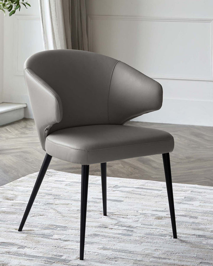 Sleek gray leather chair with a rounded back and black tapered legs, elegantly designed for modern spaces.