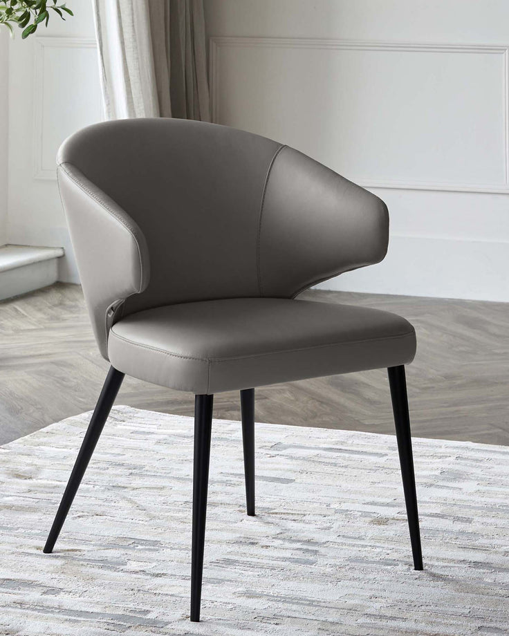 Sleek gray leather chair with a rounded back and black tapered legs, elegantly designed for modern spaces.