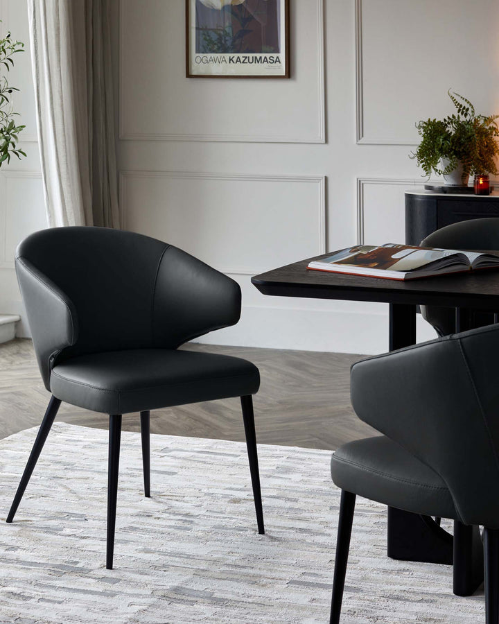 Landon black leather dining chair with curved backrest and black metal legs, shown at a dining table in a modern room setting.