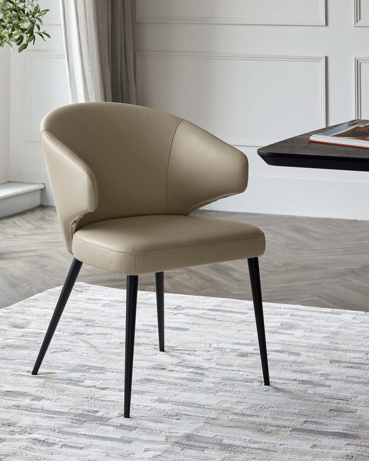 A modern, curved beige chair with a sleek design and black tapered legs, placed on a textured light rug.