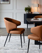 Tan leather dining chair with curved backrest and black metal legs, shown in a modern dining room setting.