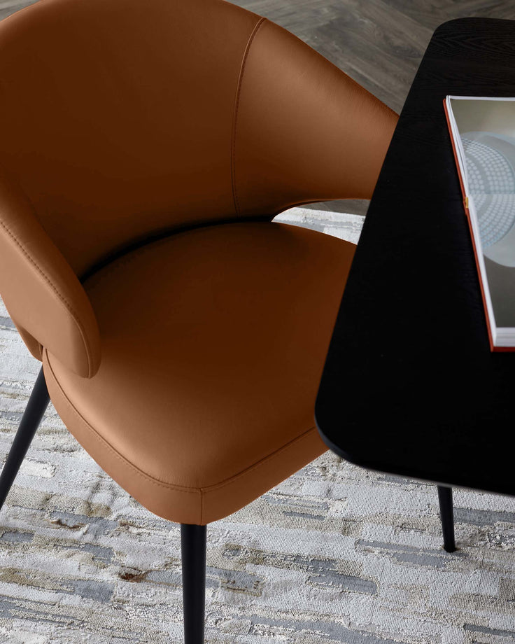 Tan leather dining chair with curved backrest and black metal legs, shown at an angle in a modern interior setting.