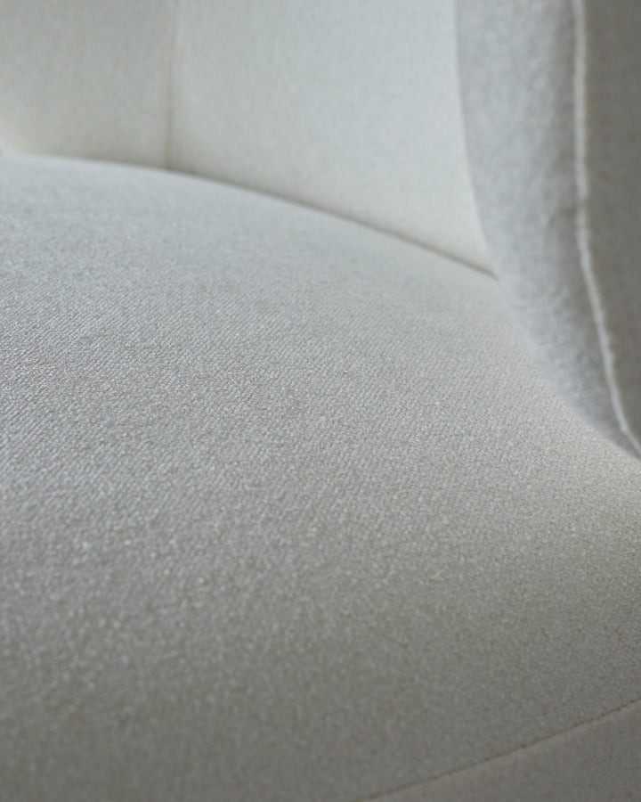 Close-up of a white, textured sofa. The soft, neutral fabric is the focus, ideal for a minimalist interior.