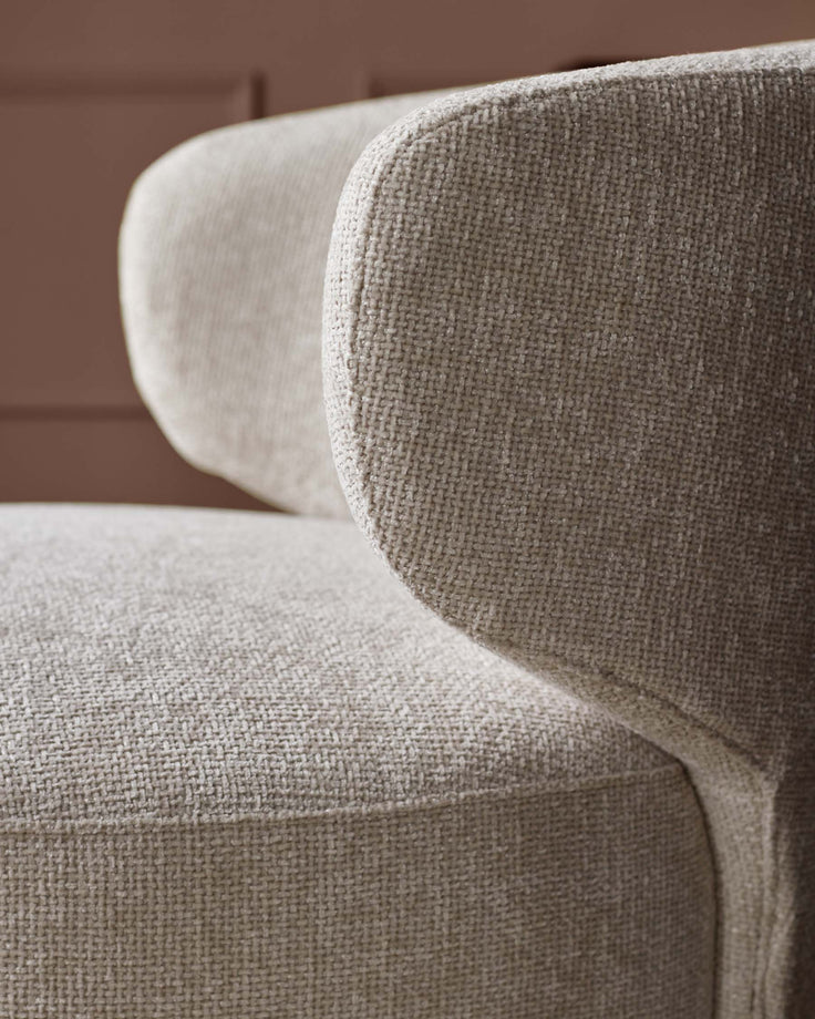 Close-up of an upholstered chair. Light textured fabric. Modern design. Comfort and style for your living space.