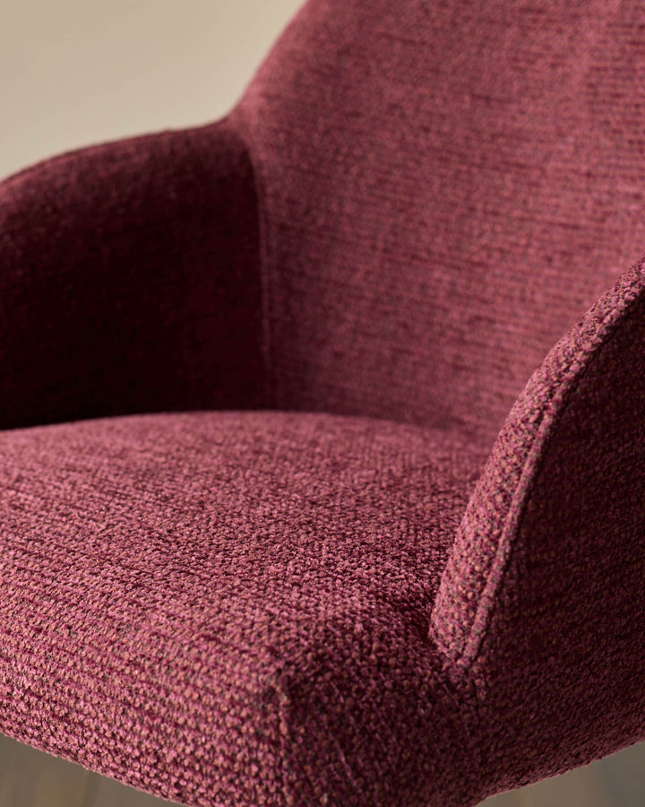 Close-up of a stylish armchair in a rich, textured maroon fabric. A cosy and inviting furniture piece.