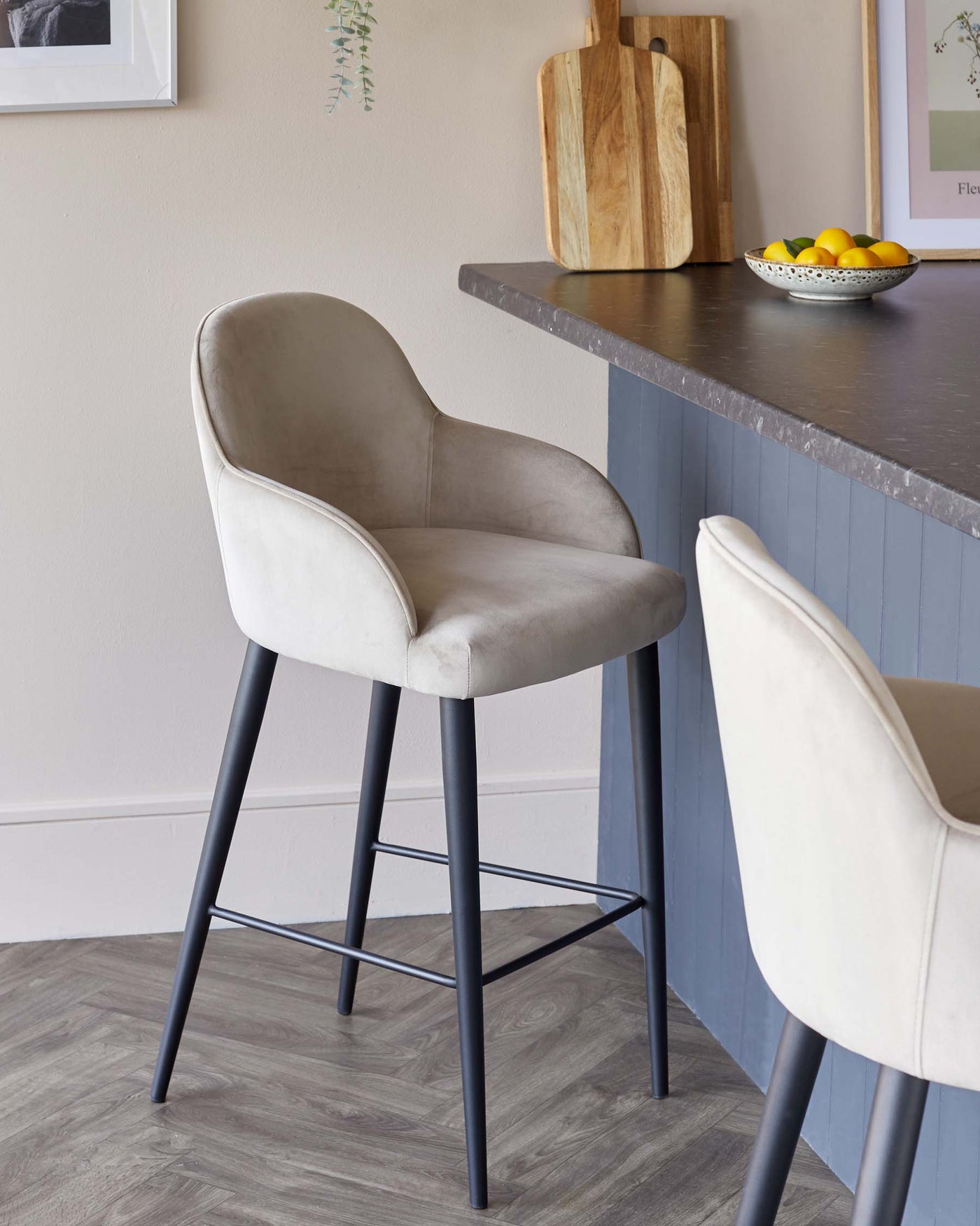 Modern velvet upholstered bar stools with black metal legs in a stylish kitchen setting.