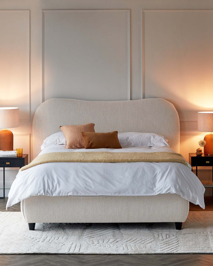 Contemporary upholstered bed with a soft, curved headboard, accent pillows, and warm lamps beside stylish nightstands.