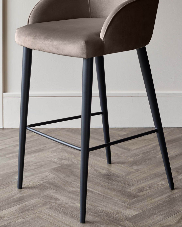 Lani bar stool in mocha velvet with black wooden legs and footrest, shown at an angle on herringbone wood flooring.