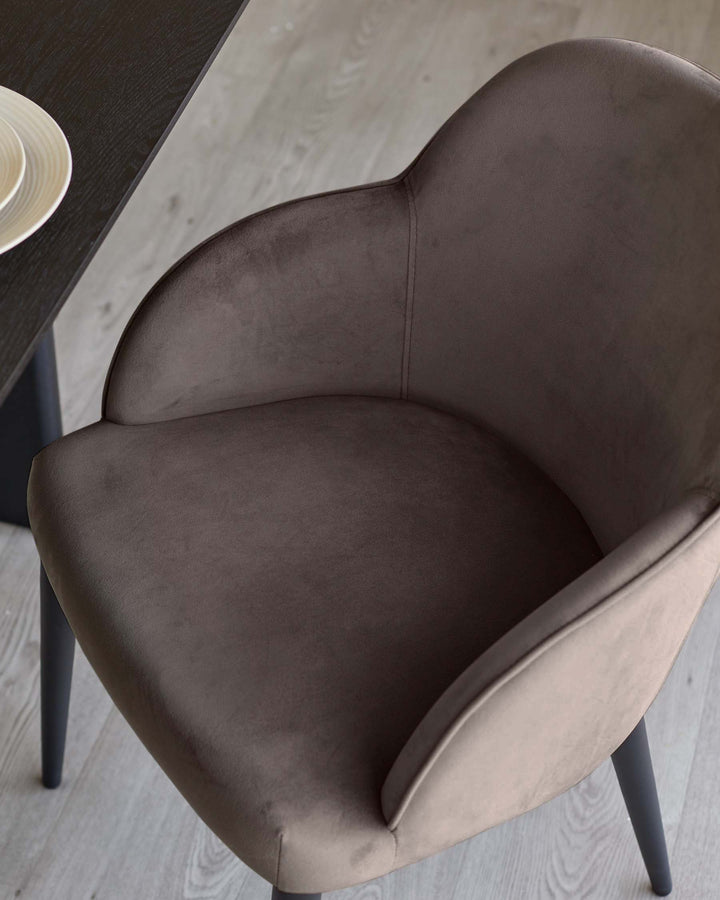 Lani dining chair in mocha velvet, shown from above at an angle, displaying curved backrest and seat cushioning with dark legs.