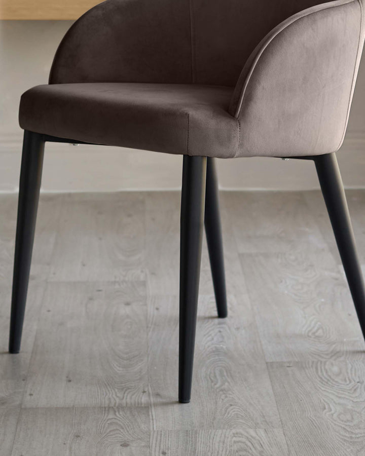 Lani dining chair in mocha velvet with curved backrest and black tapered legs, side view on light wood floor.