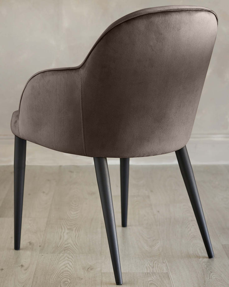 Lani dining chair in mocha velvet, rear view showing curved backrest and tapered black legs on light wood flooring.