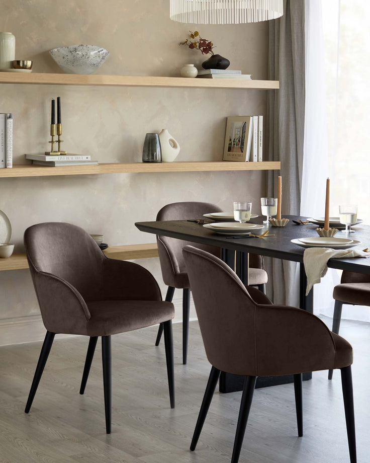 Mocha velvet dining chair with curved backrest and black tapered legs, shown in dining room setting.