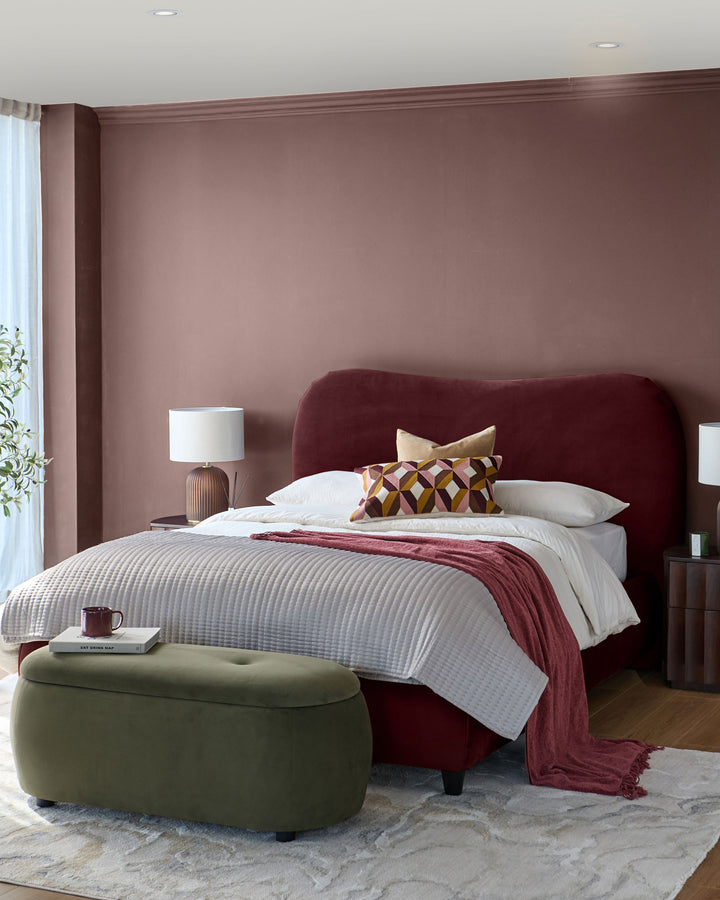 Lani King Ottoman Bed in plum velvet, shown in a bedroom setting with white bedding and coordinating décor.