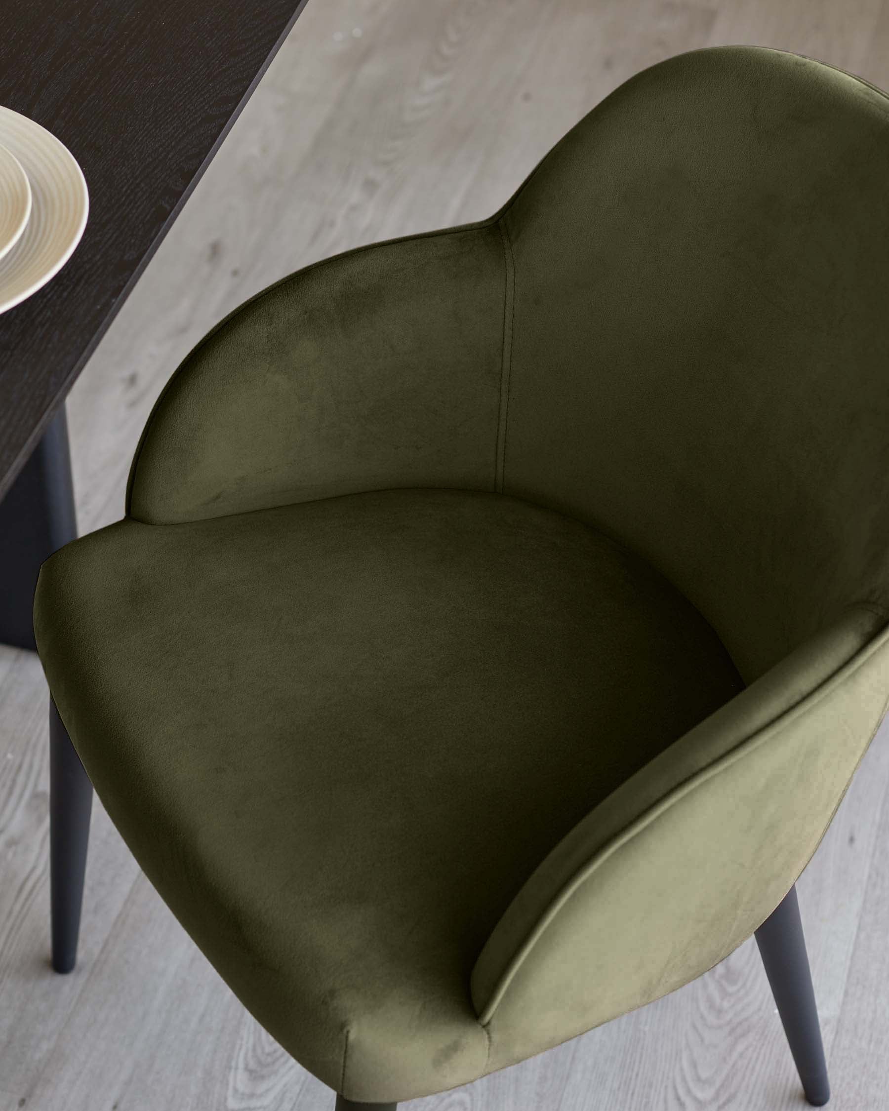 Lani dining chair in olive green velvet, overhead view showing curved backrest and seat cushion with dark legs.