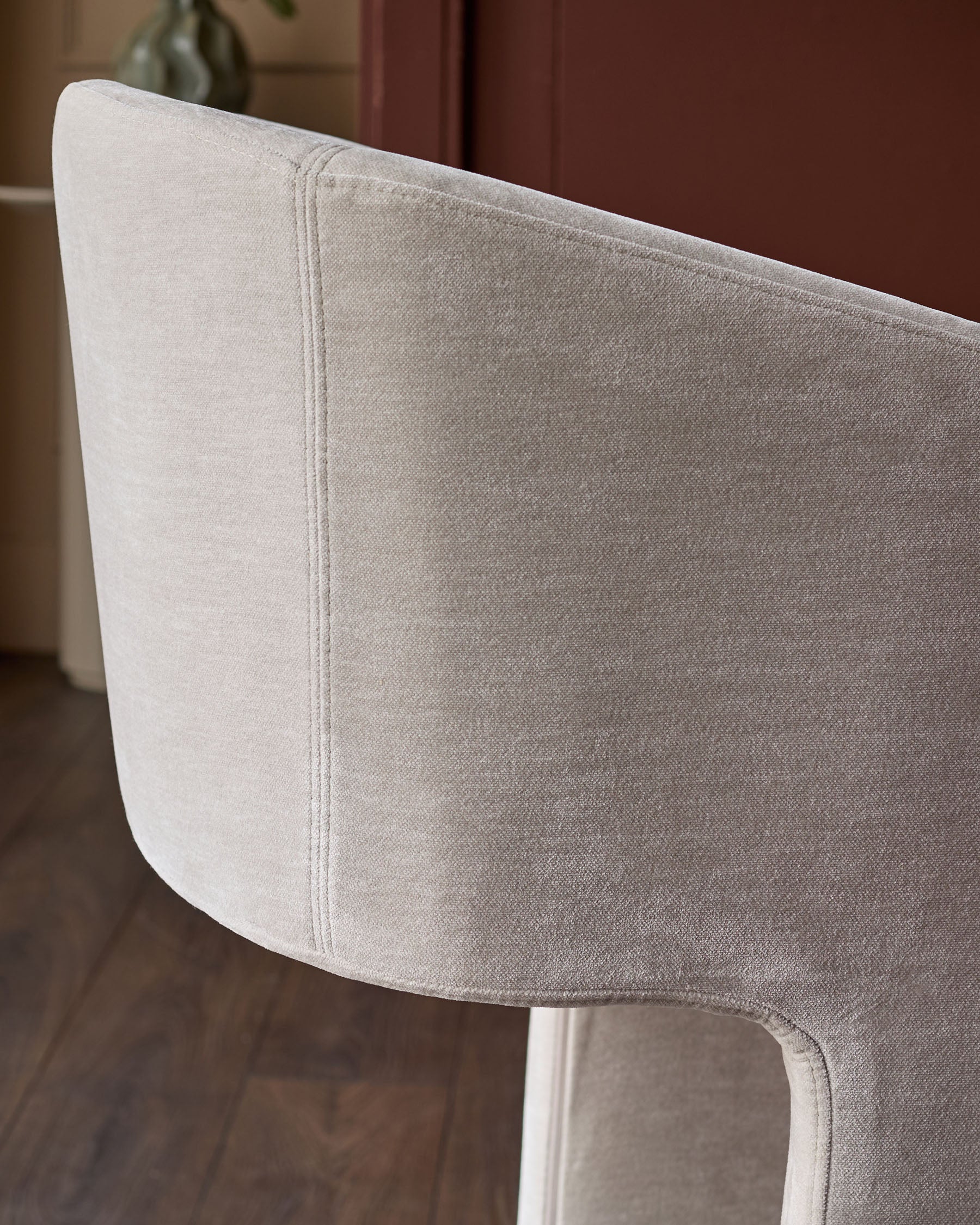 Leighton bar stool close-up showing natural grey fabric seat and white metal frame leg.