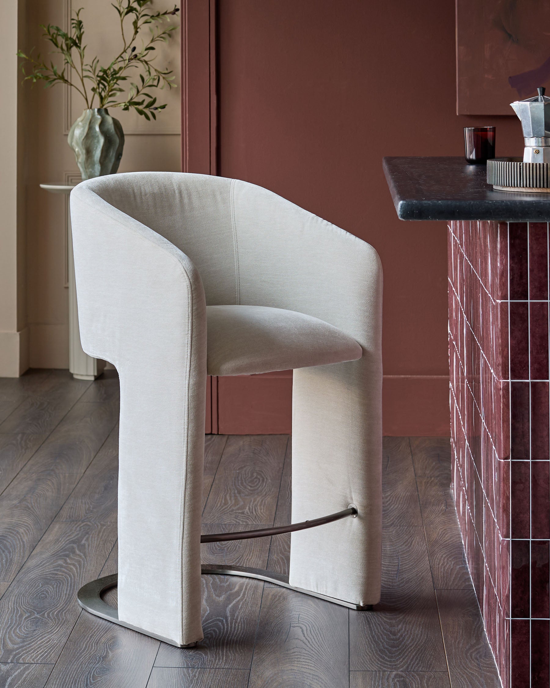 Leighton bar stool in natural grey fabric with black steel cantilever base, shown in modern interior setting.